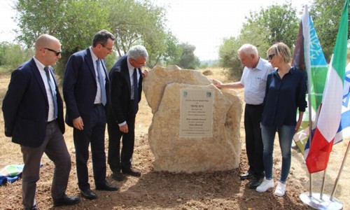 משתתפי טקס הקדשת הסינגל לזכר ג'ינו ברטלי ליד שלט ההקדשה