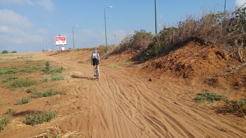 רוכב אופניים בדרך עפר חקלאית בדרך להרצליה