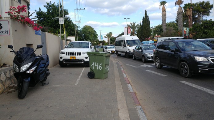 פחי אשפה מפריעים לתנועת הולכי רגל ורוכבי אופניים בשדרות קרן קיימת לישראל בתל אביב